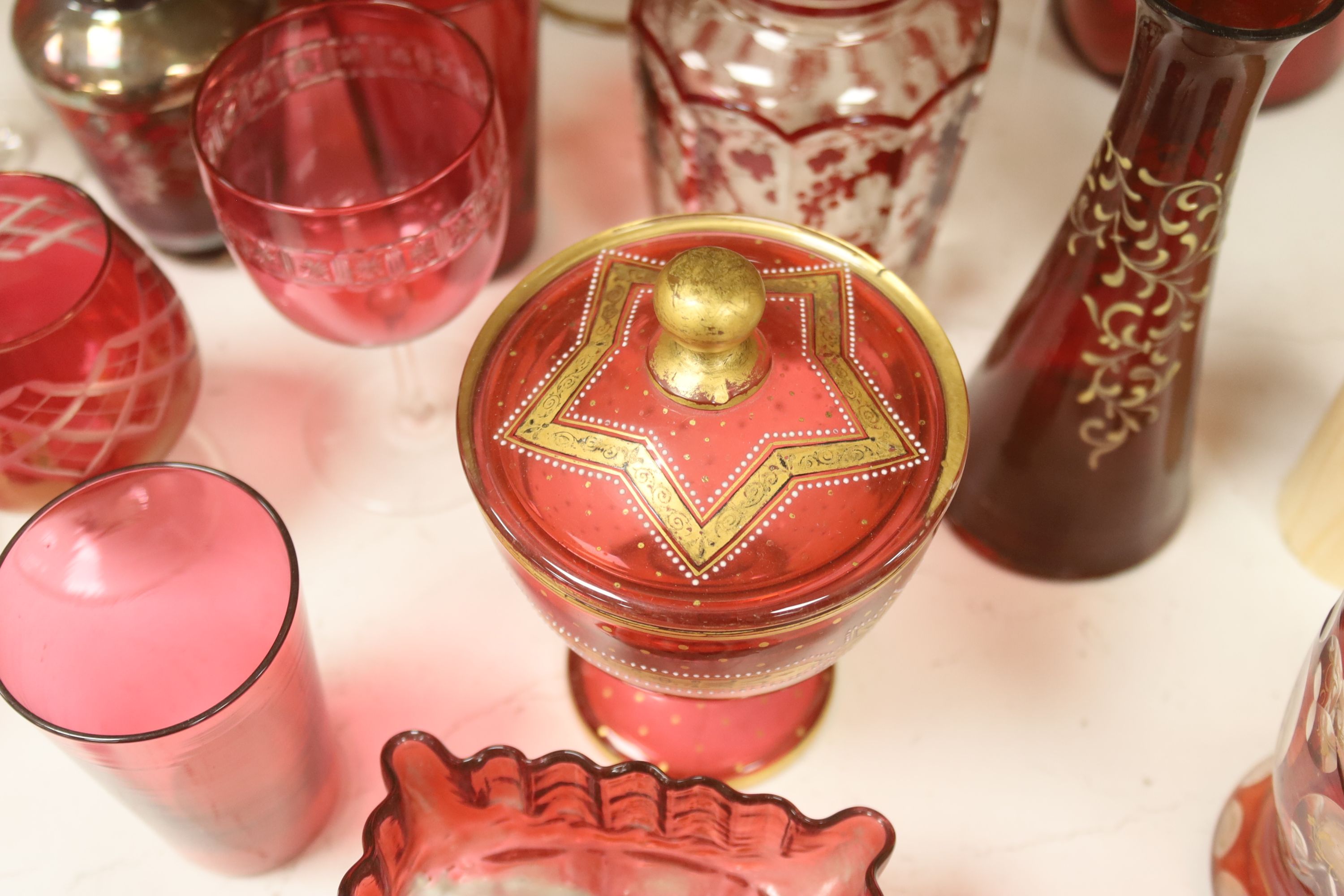 A collection of cranberry and ruby glassware including a 'Mary Gregory' vase